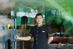 a man holding an umbrella in front of a window at Ping Hotel in Hanoi