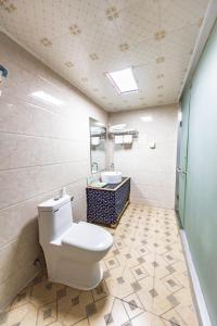 ein Bad mit einem WC und einem Waschbecken in der Unterkunft Jinan Mountain and Sea Culture Hotel in Jinan