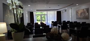 une salle de conférence avec des chaises noires et une grande fenêtre dans l'établissement Villa Gaga, à Međugorje