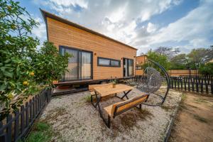 ein winziges Haus mit einem Tisch und einer Bank in der Unterkunft Gaia Tiny Houses Butik Hotel in Bodrum City