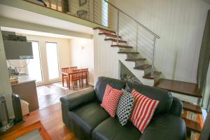 Allambie Cottages - Villa 2 في برايت: غرفة معيشة مع أريكة خضراء مع وسائد +صورة واحدة