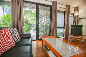 Allambie Cottages - Villa 2 في برايت: غرفة معيشة مع أريكة وطاولة زجاجية