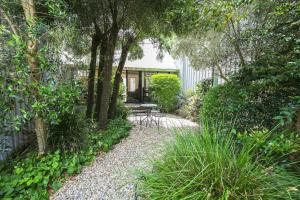 Allambie Cottages - Villa 2 في برايت: حديقة فيها طاولة وكراسي واشجار