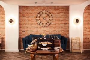 a brick wall with a clock and a table at Neueröffnung 2024 Grand Hotel Nautimar in Büsum