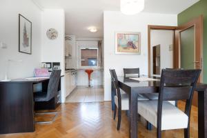 Apartment Adagio في زغرب: مطبخ وغرفة طعام مع طاولة وكراسي