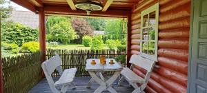a table and chairs on a porch of a cabin at Cottage - Liepų Sodyba in Joniškėlis