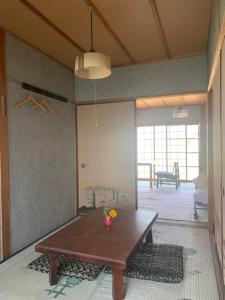 een woonkamer met een houten tafel in een kamer bij Kanzaki Beach House 