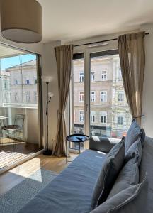 uma sala de estar com um sofá e uma grande janela em Vienna Sunny Side Up Apartments em Viena