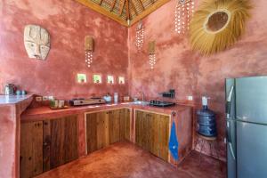 a kitchen with wooden cabinets and a refrigerator at Villa Mandala in Gili Air