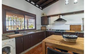 a kitchen with a table and a washing machine at Villa María Lagos del Serrano in Seville