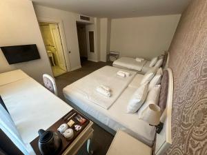 una piccola stanza con due letti e una televisione di Hanzade Park Hotel a Trabzon Altre 60 foto