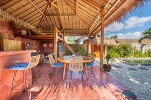 a dining room with a table and chairs on a patio at Villa Mandala in Gili Air