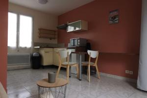 a kitchen with a table and chairs in a room at Studio avec jardin in Bourcefranc +4 photos