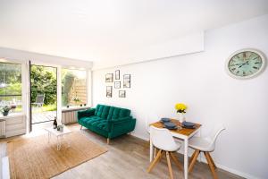 ein Wohnzimmer mit einem grünen Sofa und einem Tisch in der Unterkunft FeWo C 1-2 "Kleine Auszeit" in Sierksdorf