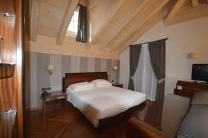 um quarto com uma cama e uma televisão num quarto em Villa Madonna em Madonna di Campiglio