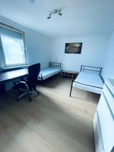 a room with two beds and a desk and a chair at Privatzimmer Staver in Weisenbach