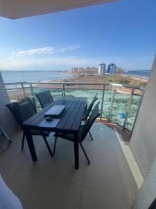 un tavolo e sedie su un balcone con vista sull'oceano di Apartamento Pudrimel a San Blas