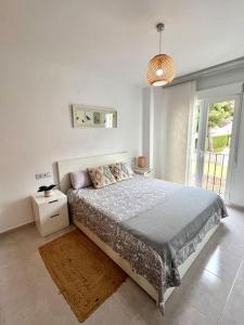 a bedroom with a bed and a pendant light at Apartamento junto campo de GOLF LA SELLA in Muntanya la Sella