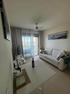 un soggiorno con un divano bianco e un tavolo di Apartamento Pudrimel a San Blas