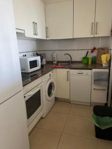 una cucina con mobili bianchi e un forno a microonde di Apartamento Pudrimel a San Blas