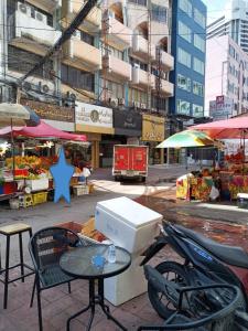 an outdoor market with a table and chairs and umbrellas at Orchid Inn SKV3 in Bangkok