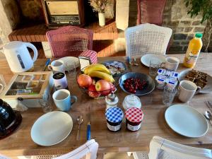 a wooden table with a bowl of fruit on it at Chambre de Ninon - Le Refuge des Parachutistes - en bordure du marais in Neuville-au-Plain