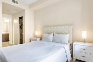 a white bedroom with a large bed and two lamps at Luxury 2 Bedroom 2 Bathroom With Fitness Center and Pool in Los Angeles +40 photos
