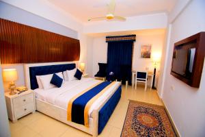 a bedroom with a large bed and a television at Premier Inn Express Gulberg Lahore in Lahore