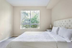 a white bedroom with a large bed with a window at Luxury 2 Bedroom 2 Bathroom With Fitness Center and Pool in Los Angeles +8 photos