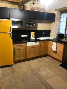 a kitchen with a yellow refrigerator and wooden cabinets at La maison villeroise in Villiers-les-Hauts