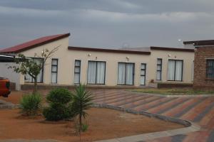 un edificio blanco con ventanas y escaleras en la parte delantera en Lesiba guesthouse, en Kwamhlanga