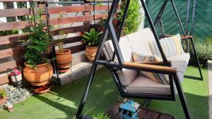 um alpendre com uma cadeira e vasos de plantas em Zoe garden home em Spata