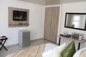a living room with a tv on the wall at Lesiba guesthouse in Kwamhlanga