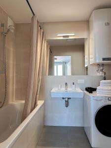 W łazience znajduje się umywalka, wanna i prysznic. w obiekcie Vienna Sunny Side Up Apartments w Wiedniu