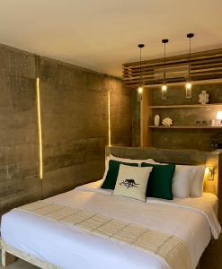 a bedroom with a large bed with green and white pillows at The CIVYT in Ubud