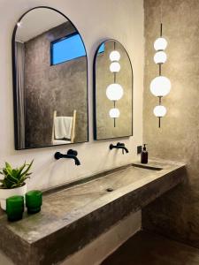 een badkamer met een wastafel en een grote spiegel bij The CIVYT in Ubud