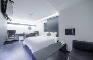 a hotel room with a white bed and a desk at Adlige Hotel in Seoul