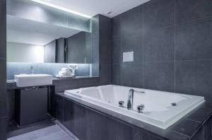 a bathroom with a large tub and a sink at Adlige Hotel in Seoul