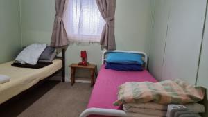 a small room with two beds and a window at Lockhart Railway Hotel in Lockhart
