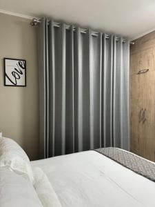 Schlafzimmer mit einem Bett und grauen Vorhängen in der Unterkunft Motswedi Place Apartments B2- Managed by Pulafela Prop Pty Ltd in Gaborone