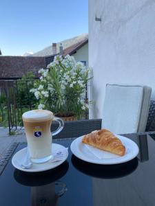 eine Tasse Kaffee und ein Gebäck auf dem Tisch in der Unterkunft Garni Sonne in Mals im Vinschgau