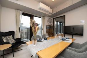 een woonkamer met een tafel en een televisie bij Regale Dotonbori East in Osaka