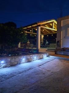 a patio with a stone wall and lights at night at Kuća za odmor Neva in Nečujam +52 photos