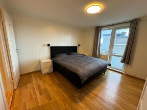 a bedroom with a bed and a large window at Charming 3-Bedroom Apartment in the Heart of Kristiansund in Kristiansund