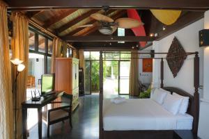 a bedroom with a bed and a ceiling fan at Villa Emerald Sand - Beach Front 4 Bed Pool Villa in Koh Samui  +35 photos