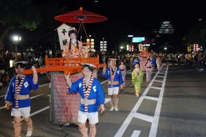 a group of people walking down a street in a parade at WholeHouse Himeji Castle ホールハウス 姫路 in Himeji