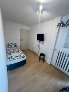 1 dormitorio con 1 cama y TV de pantalla plana en Pokoje Brynów, en Katowice