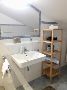 une salle de bain avec un lavabo et une étagère avec des serviettes dans l'établissement Buchnerhof Urlaub auf dem Bauernhof, à Bernau am Chiemsee