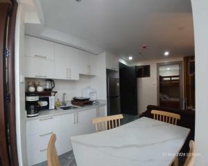 碧瑶Modern 1Bedroom Condo,with heated Roofdeck pool by Mist and Pine的配有白色橱柜、桌子和椅子的厨房