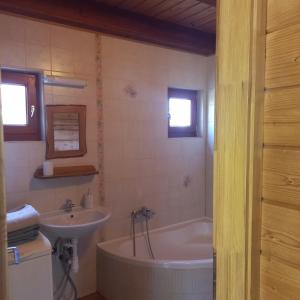 een badkamer met een bad en een wastafel bij Málnás Vendégház-Raspberry Guesthouse in Nagymaros